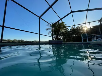 a swimming pool in a building with a glass wall at Its A Dream Family Vacation Rental - Minutes from Disney in Kissimmee