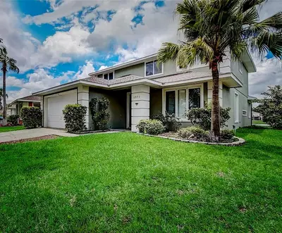 a house with a palm tree in a yard at Its A Dream Family Vacation Rental - Minutes from Disney in Kissimmee