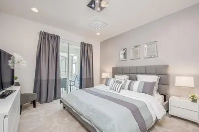 a bedroom with a large bed and a television at Premium Comfort - Beautiful Home Private Pool in Kissimmee
