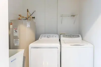 a kitchen with two machines and a refrigerator at 4br House w Perfect Location Pool and Much More in Kissimmee