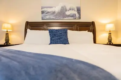 a bedroom with a large bed with a blue pillow at 3BR Townhouse w Perfect Location in Orlando