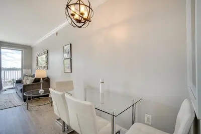 a dining room with a glass table and white chairs at 1 Mi to Disney World Lakefront Condo in Orlando! in Orlando