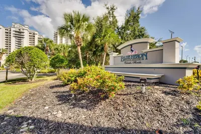 a sign for the front of a building with palm trees at 1 Mi to Disney World Lakefront Condo in Orlando! in Orlando