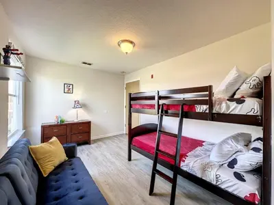 a bedroom with two bunk beds and a couch at Lovely 3 bed Condo Near Disney Quiet Community condo in Kissimmee