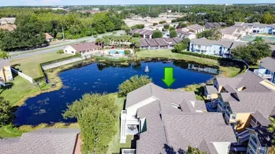 an aerial view of a home with a pond in the backyard at Lovely 3 bed Condo Near Disney Quiet Community condo in Kissimmee