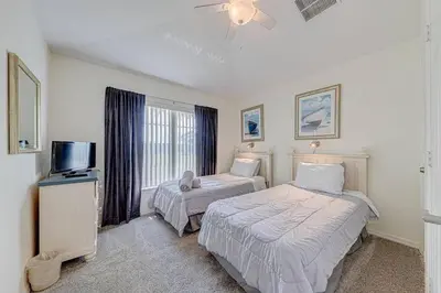 a bedroom with two beds and a flat screen tv at 545 -Beautiful 4 Bed Home with Sparkling Pool and Games Room in Orlando