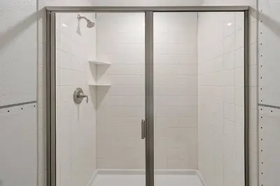 a shower with a glass door in a bathroom at NEW Themed 10B VillaPoolSpa in Kissimmee