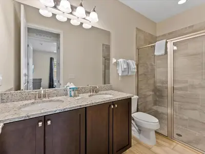 a bathroom with a toilet and two sinks and a shower at Family Friendly Home With Private Pool, Game Room, Waterpark & Resort Access Near Disney At Encore Resort - 7638Wi in Kissimmee