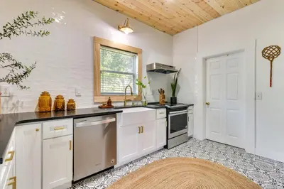 a kitchen with white cabinets and a sink at Fire Pit and Yard Updated Winter Garden Home! in Orlando
