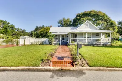 a white house with a porch and a yard at Fire Pit and Yard Updated Winter Garden Home! in Orlando