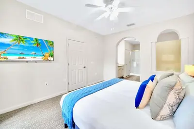 a white bedroom with a bed and a ceiling fan at 2BR Queen bed Condo - Pool - Near Disney in Orlando