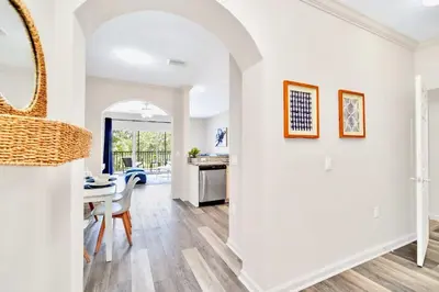 a dining room and living room with a table and chairs at 2BR Queen bed Condo - Pool - Near Disney in Orlando