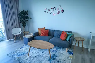 a living room with a blue couch and a table at Orlando 5th Floor 5 min from disney in Orlando