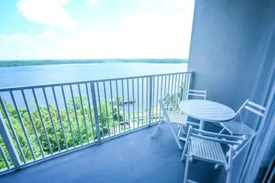 a balcony with a table and chairs and a view of the water at Orlando Apt 9th Floor 5 min from Disney in Orlando