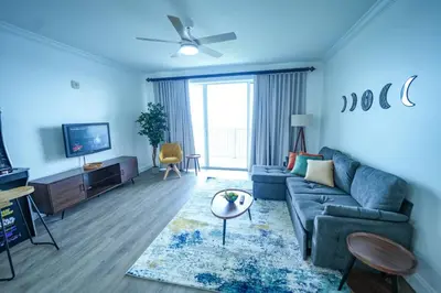 a blue living room with a couch and a tv at Orlando Apt 9th Floor 5 min from Disney in Orlando