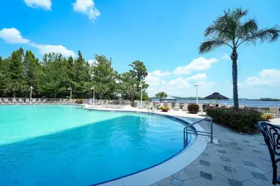 a swimming pool at a resort with a palm tree at Orlando Apt 10th floor 5 min from Disney in Orlando