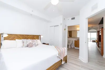 a white bedroom with a large bed and a bathroom at Orlando Blue Heron condo 1 mile from Disney in Orlando