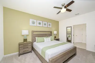 a bedroom with a bed and a ceiling fan at 15BR Mansion Near Disney Private Pool Hot Tub in Kissimmee