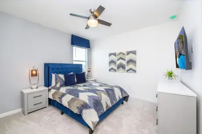a bedroom with a blue bed and a ceiling fan at 15BR Mansion Near Disney Private Pool Hot Tub in Kissimmee