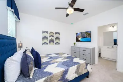 a bedroom with a blue and white bed and a sink at 15BR Mansion Near Disney Private Pool Hot Tub in Kissimmee