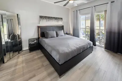 a bedroom with a large bed and a large window at Amazing Disney Themed Oasis 3BR near Parks townhouse in Orlando