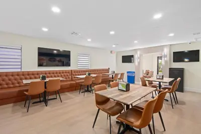 a restaurant with tables and chairs and a couch at Baymont by Wyndham Orlando Downtown in Orlando