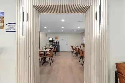 a hallway with tables and chairs in a restaurant at Baymont by Wyndham Orlando Downtown in Orlando