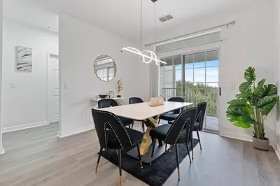 a white dining room with a table and chairs at Amazing Apartment 3Brdm - 5 miles from Disney in Kissimmee