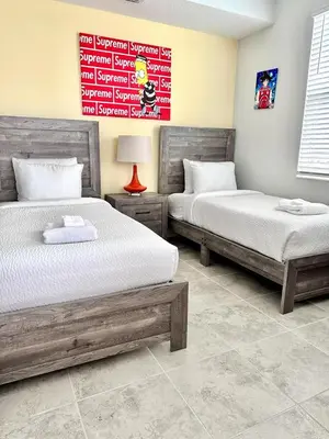 a bedroom with two beds and a sign on the wall at The Epic Miami Supreme Storey Lake in Kissimmee
