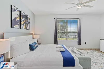 a white bedroom with a large bed and a window at The Epic Madrid Vista Cay Orlando in Orlando