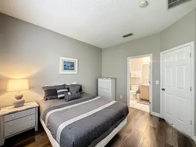 a bedroom with a large bed and a bathroom at 4 BED 3 BATH IN A GATED COMMUNITY WITH POOL villa in Kissimmee