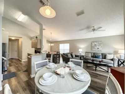 a living room with a dining table and a kitchen at 4 BED 3 BATH IN A GATED COMMUNITY WITH POOL villa in Kissimmee