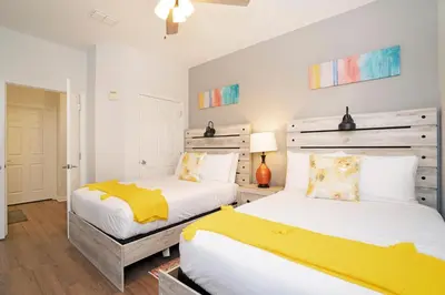 two beds in a bedroom with white and yellow at Luxury Remodeled! WOW! in Orlando