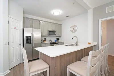 a kitchen with a stainless steel refrigerator and wooden cabinets at Luxury Remodeled! WOW! in Orlando