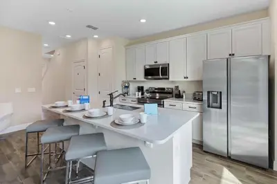 a kitchen with white cabinets and a stainless steel refrigerator at 2971 Castaway Lane in Orlando