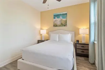 a bedroom with a white bed and two lamps at 2971 Castaway Lane in Orlando