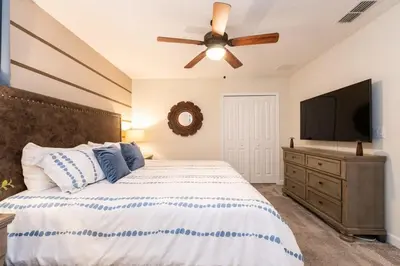 a bedroom with a bed and a flat screen tv at Magical 9BR Villa by Disney w Pool Theme Room in Kissimmee