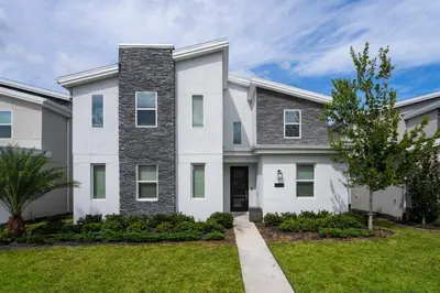 a large white house with a grass yard at Magical 9BR Villa by Disney w Pool Theme Room in Kissimmee