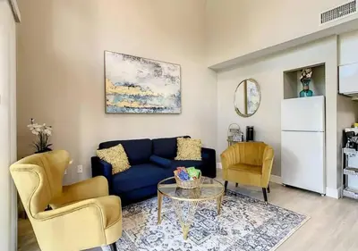 a living room with a blue couch and two chairs at Charming Lakeview Retreat III in Orlando