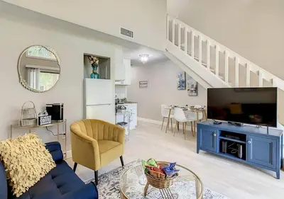 a living room with a blue couch and a tv at Charming Lakeview Retreat III in Orlando