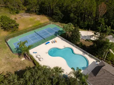an overhead view of a pool with tennis courts at The Dream Vacation Home! in Orlando