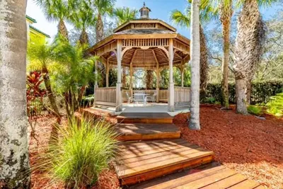 a gazebo in a garden with palm trees at Theme Park Paradise! in Kissimmee