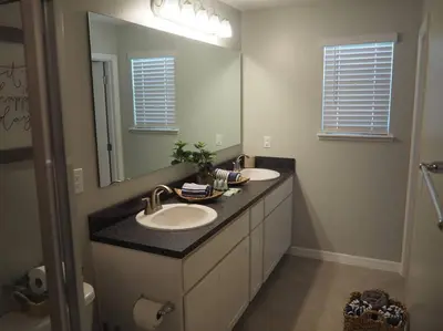 a bathroom with two sinks and a large mirror at Luxurious Farm Style House in Kissimmee
