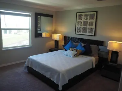 a bedroom with a large bed with blue pillows at Luxurious Farm Style House in Kissimmee