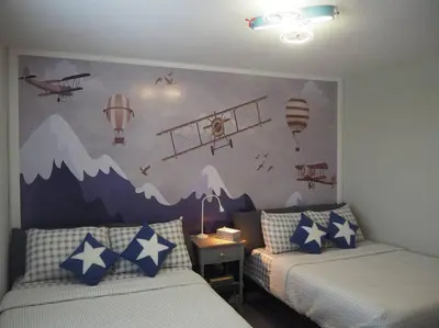 a bedroom with two beds and a mural of planes at Luxurious Farm Style House in Kissimmee