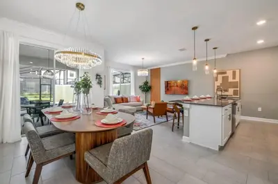 a kitchen and living room with a table and chairs at Ultimate Luxury Home-Private Pool Themed Bedroom in Kissimmee