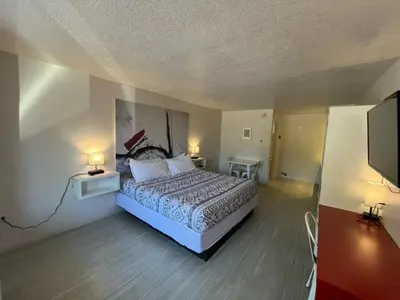 a bedroom with a bed and two lamps and a tv at A & S Vacation Rooms in Kissimmee