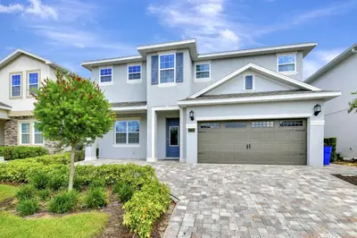 a large white house with a garage at Modern Home With Private Pool, Ping Pong Table Near Disney With Waterpark & Resort Access At Encore Resort - 7758Wl in Kissimmee