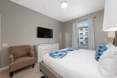 a bedroom with a bed and a chair and a television at Orlando Resort: 3BD and electric fireplace in Orlando