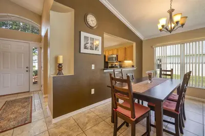 a kitchen and dining room with a table and chairs at Charming 3BR home in Kissimmee with private pool and lake view, perfect for families. in Kissimmee